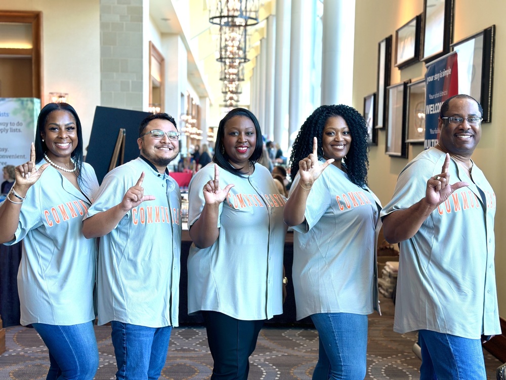 Communications team poses with "L" hand signal