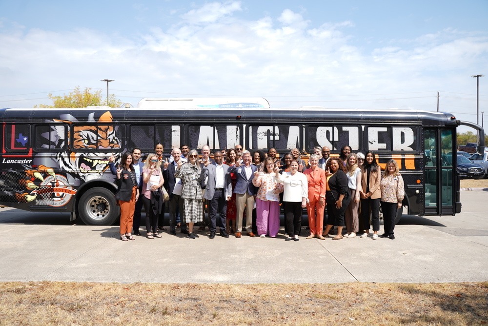 teachers and educators pose in front of Lancaster ISD bus