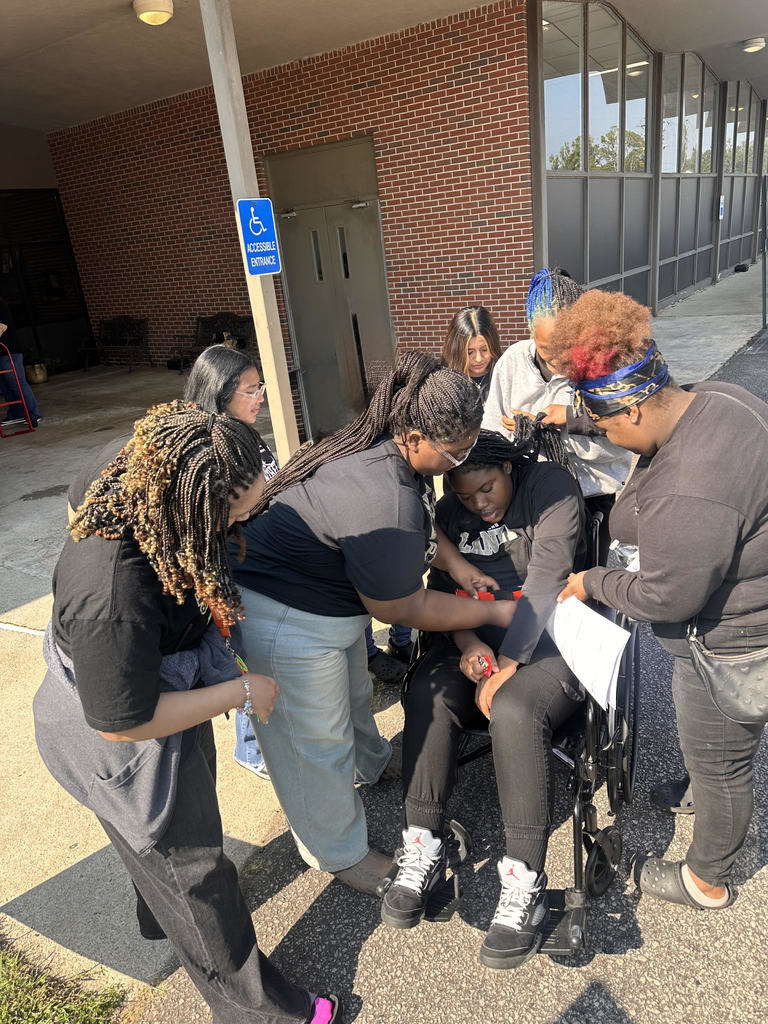 Students in the Patient Care Technician Class are learning to transfer a person from a wheelchair to a car. 