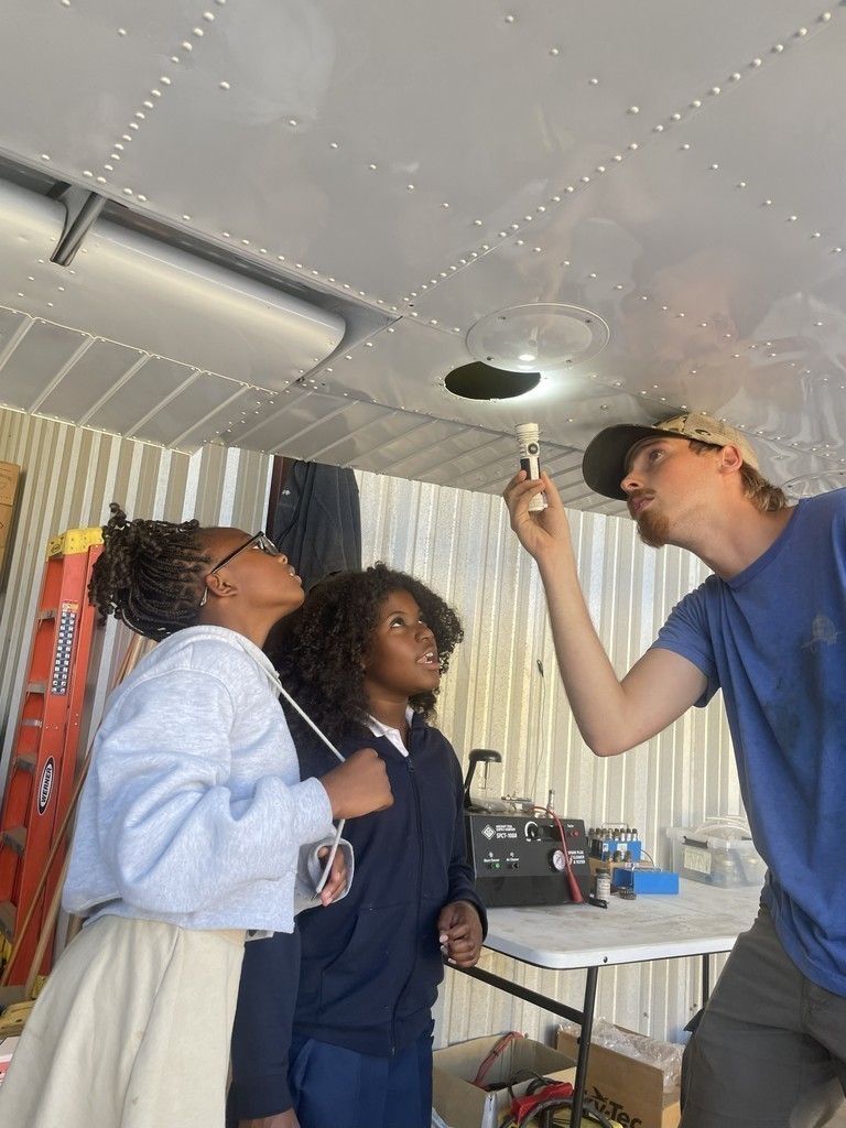 Lanett City Schools 5th and 6th grade students and teachers are at the Lanett Municipal Airport. They are shown looking closely at airplanes and various airport equipment as they learn about aviation.
