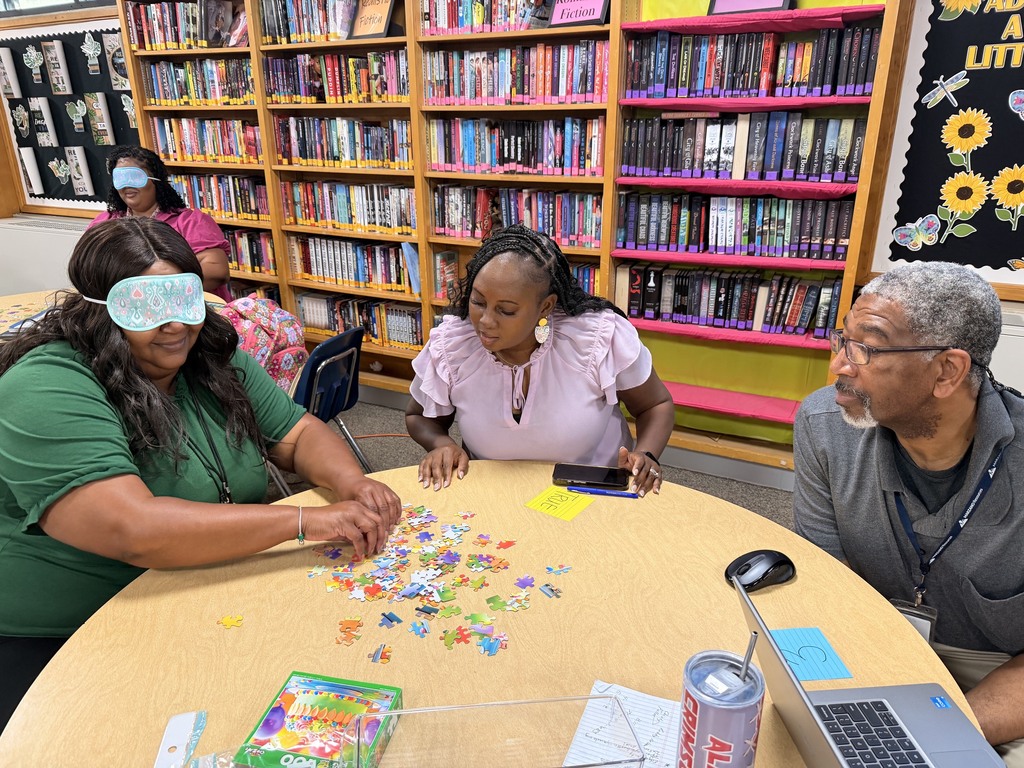 Staff working together to assemble a puzzle.