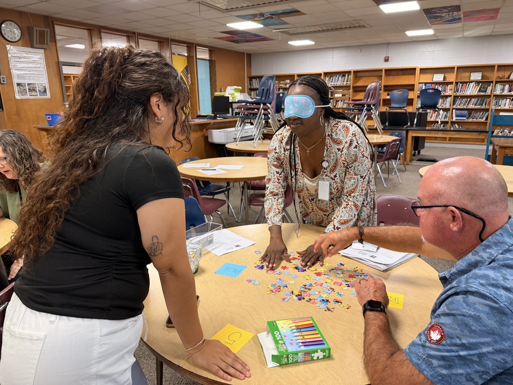 Staff working together to assemble a puzzle.