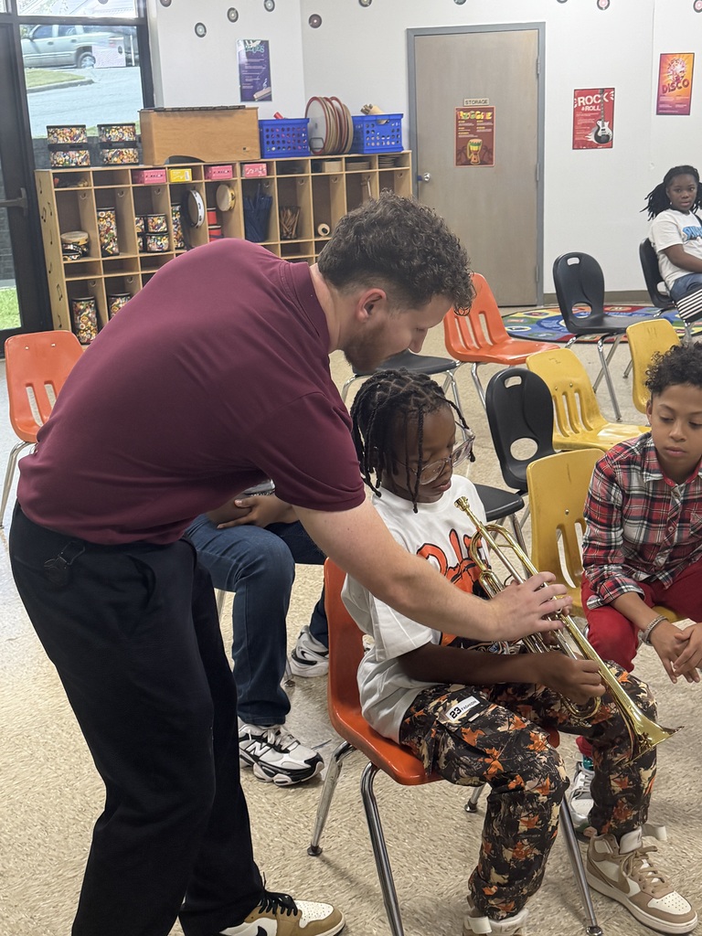 Mr. Holly helping a band student learn the trumpet