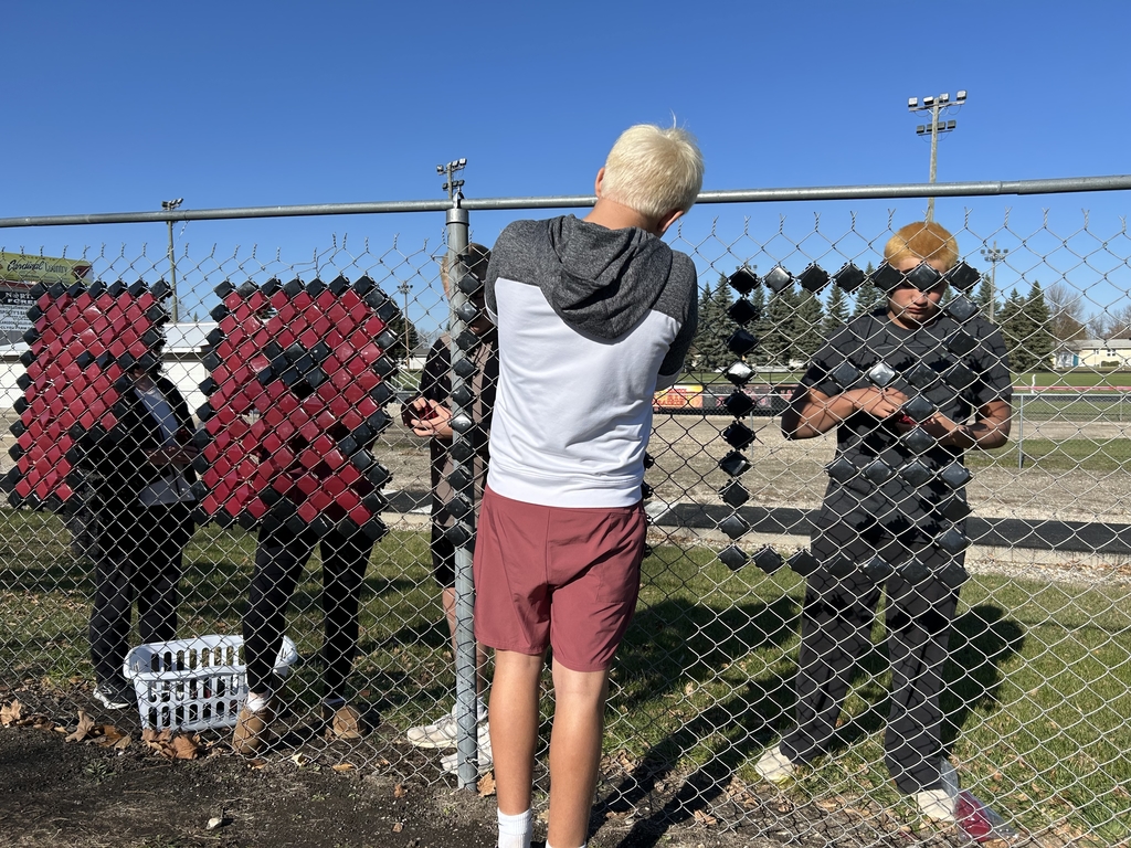 students putting up fence sign