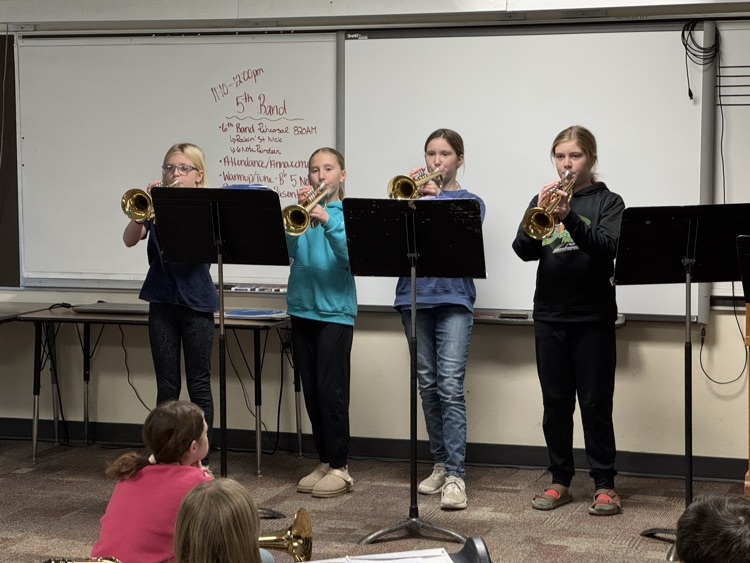 four girls playing a Christmas song on trumpet