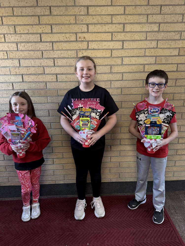 three students standing with their Valentine’s Day bouquets that they won