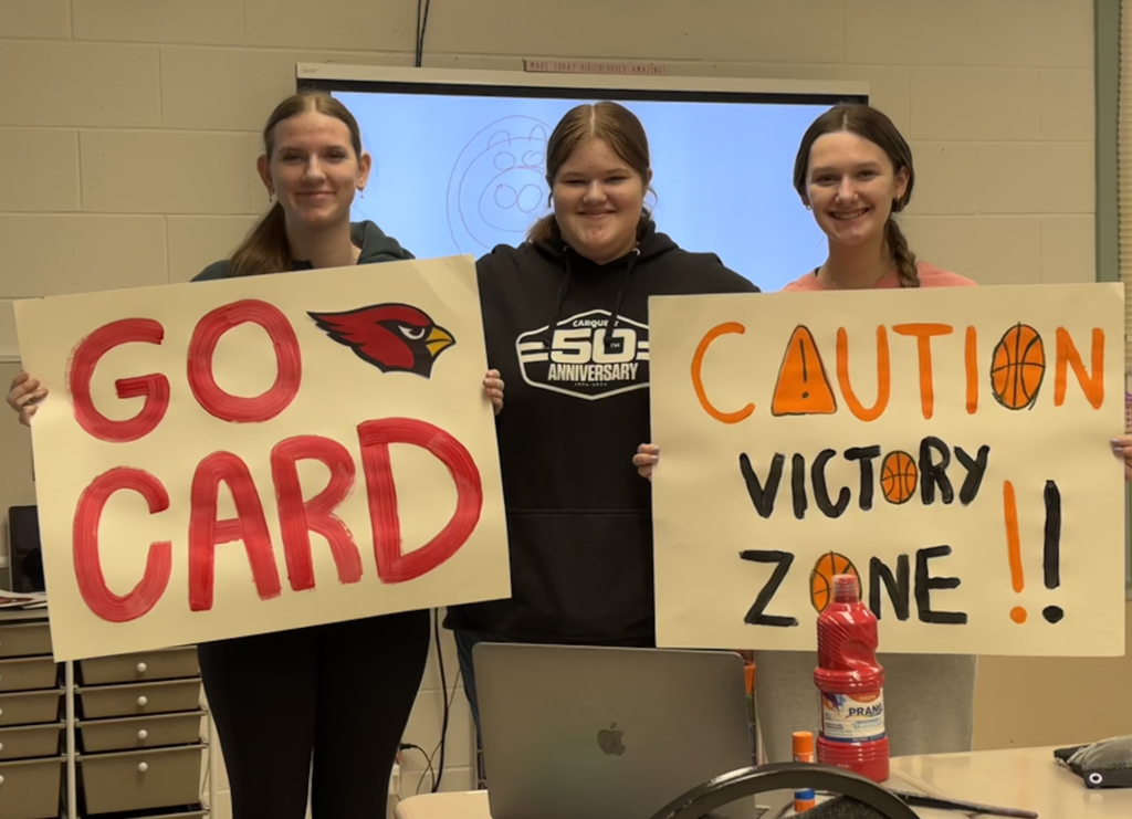 three students with two signs