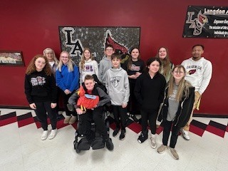 Mrs. Gudgel's group- A group of students standing together in a school hallway wearing casual clothing and backpacks.