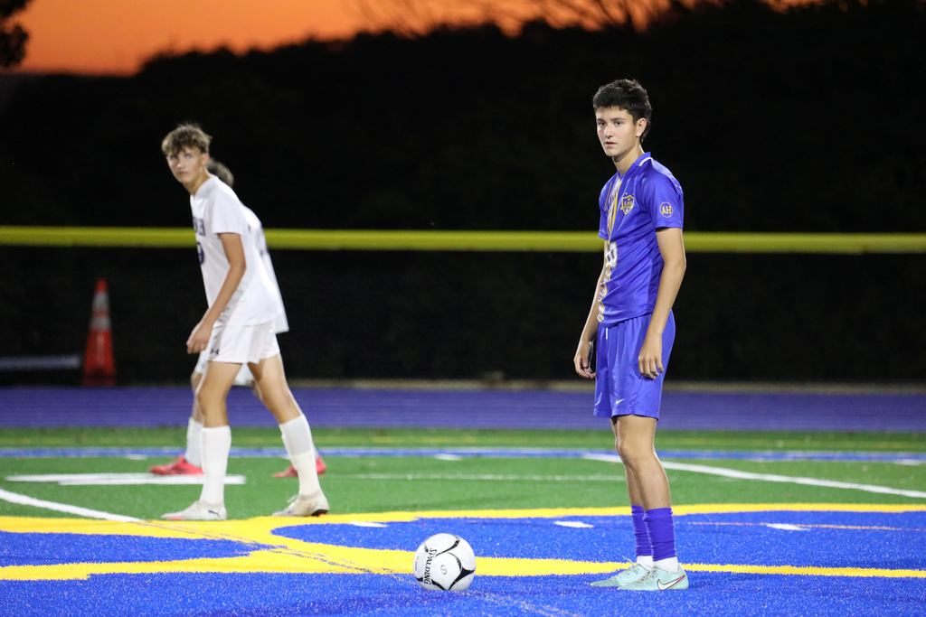 A soccer team member from the boys team standing on field