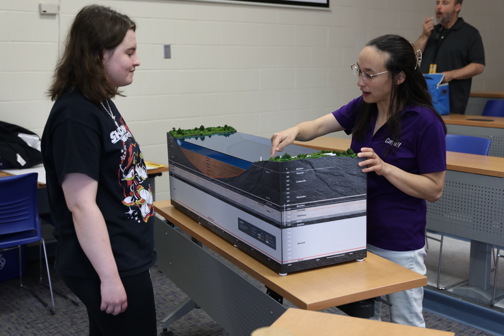 An expert from Cargill pointing out the mine entrance on the table model
