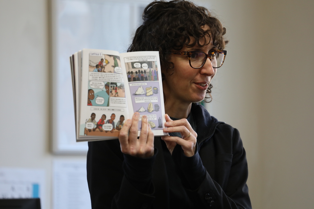 a close up of the author showing her book open faced to the class