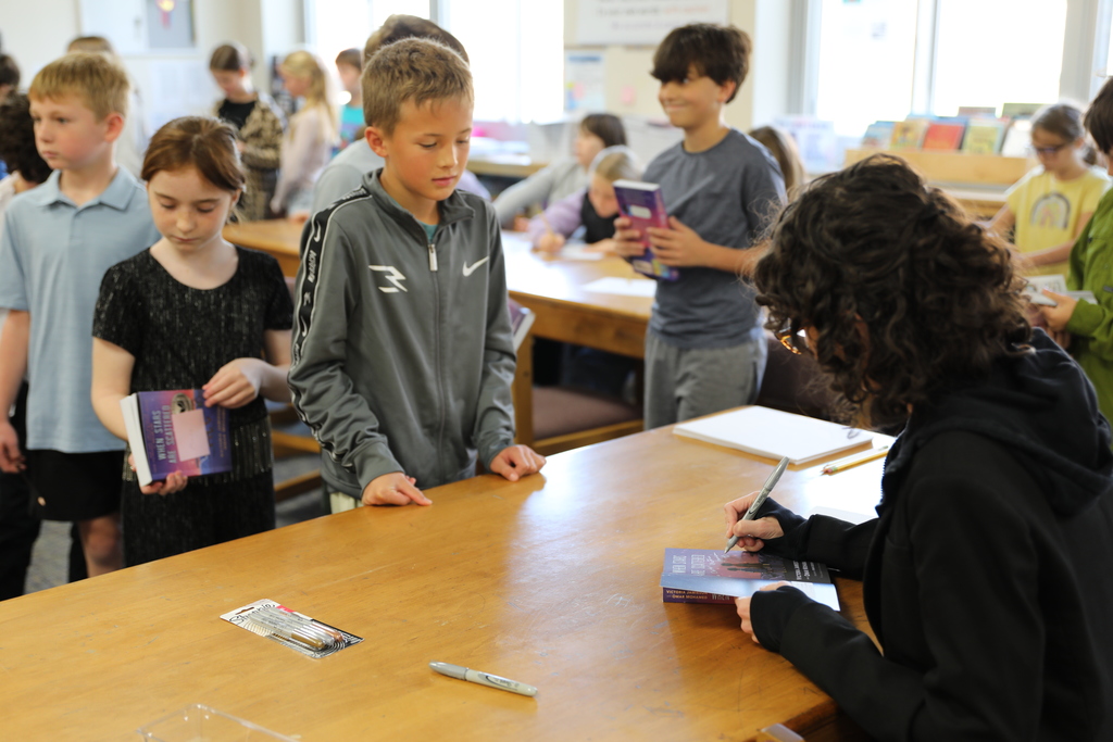 the author signing books for the students
