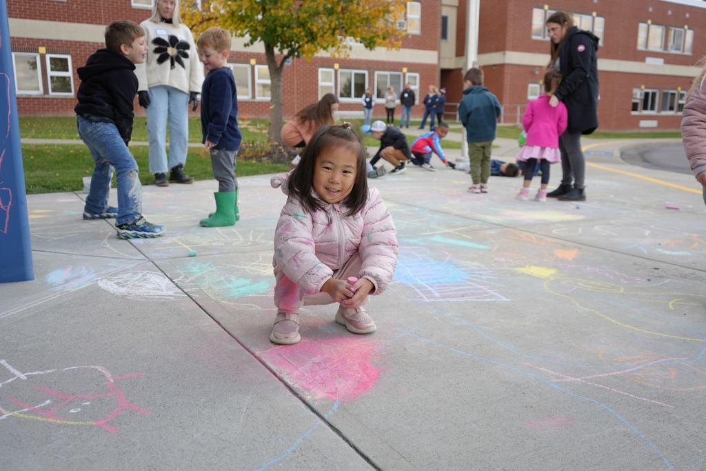 Student at fall fest coloring with chalk