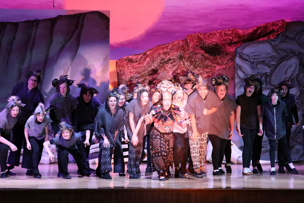 a large section of the cast posing for the audience 