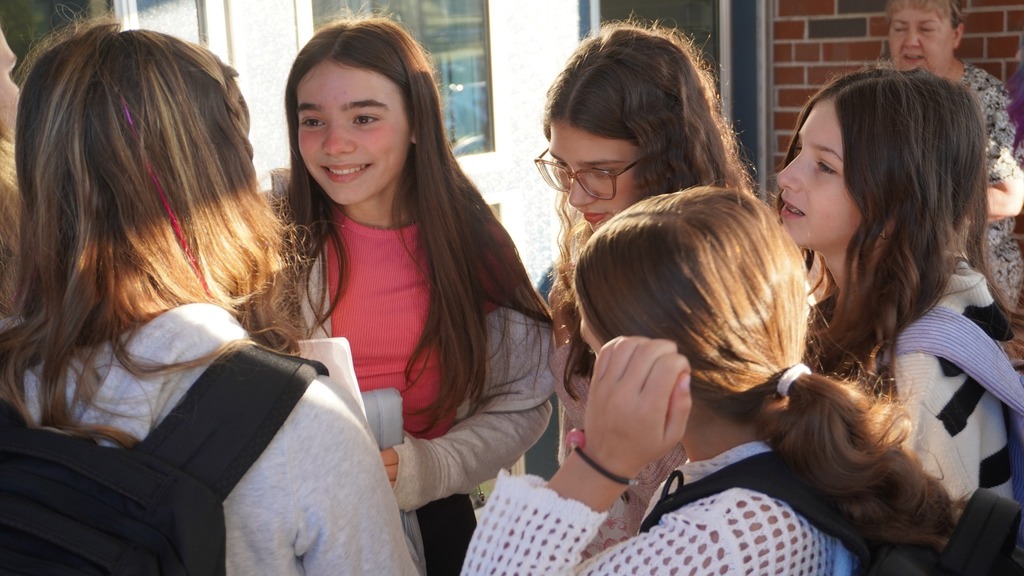 Middle school students gathered and smiling at one another