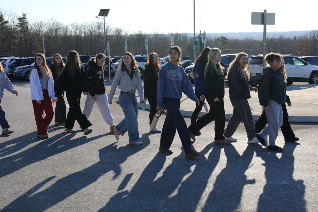 the volleyball team walking through a parking lot