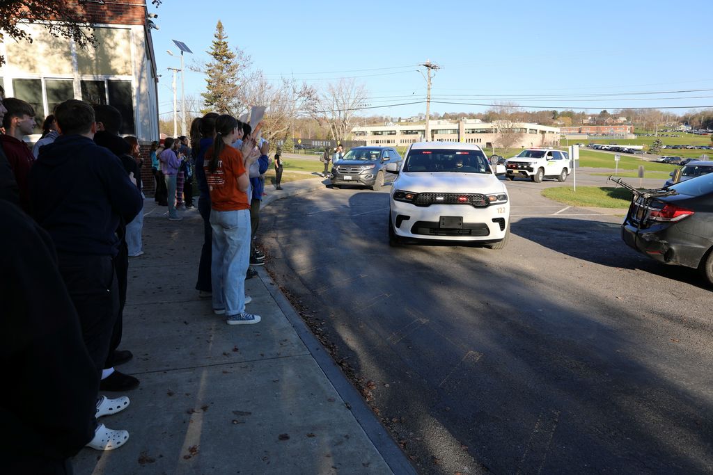a police car driving by the middle school as part of the celebratory motorcade