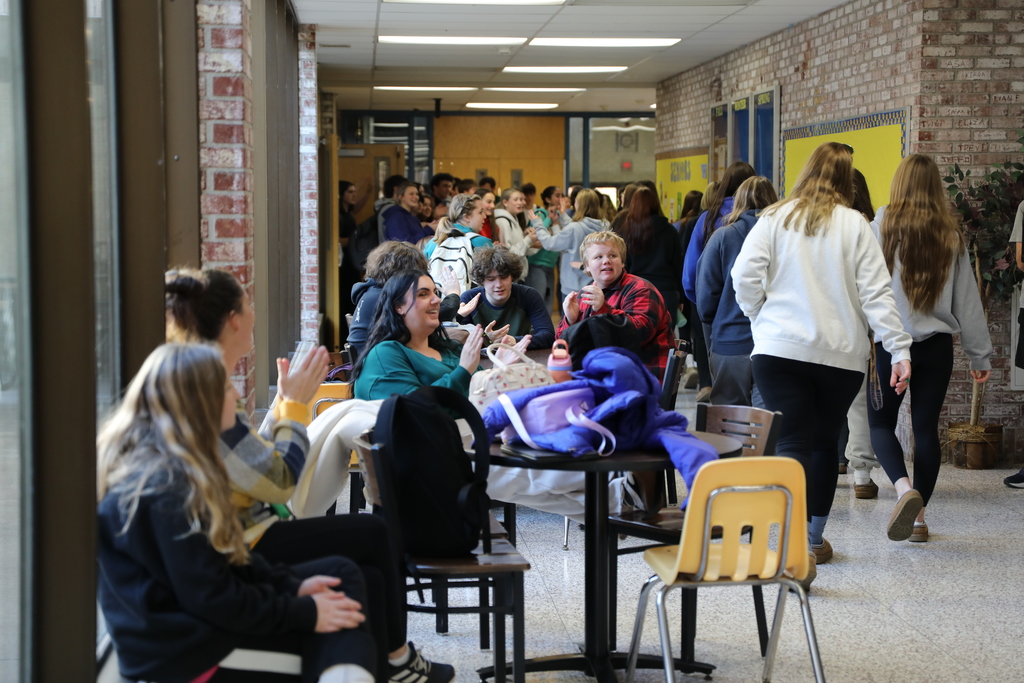 the volleyball team walking through the highschoool as they are cheered on