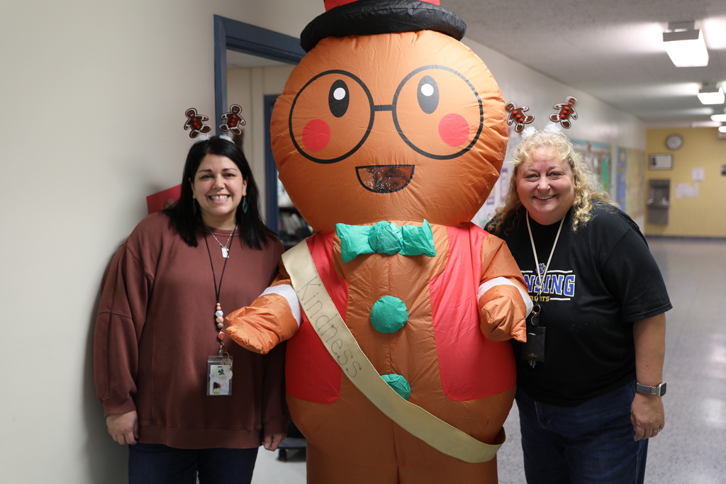 two adults posing for a picture with the gingerbread man