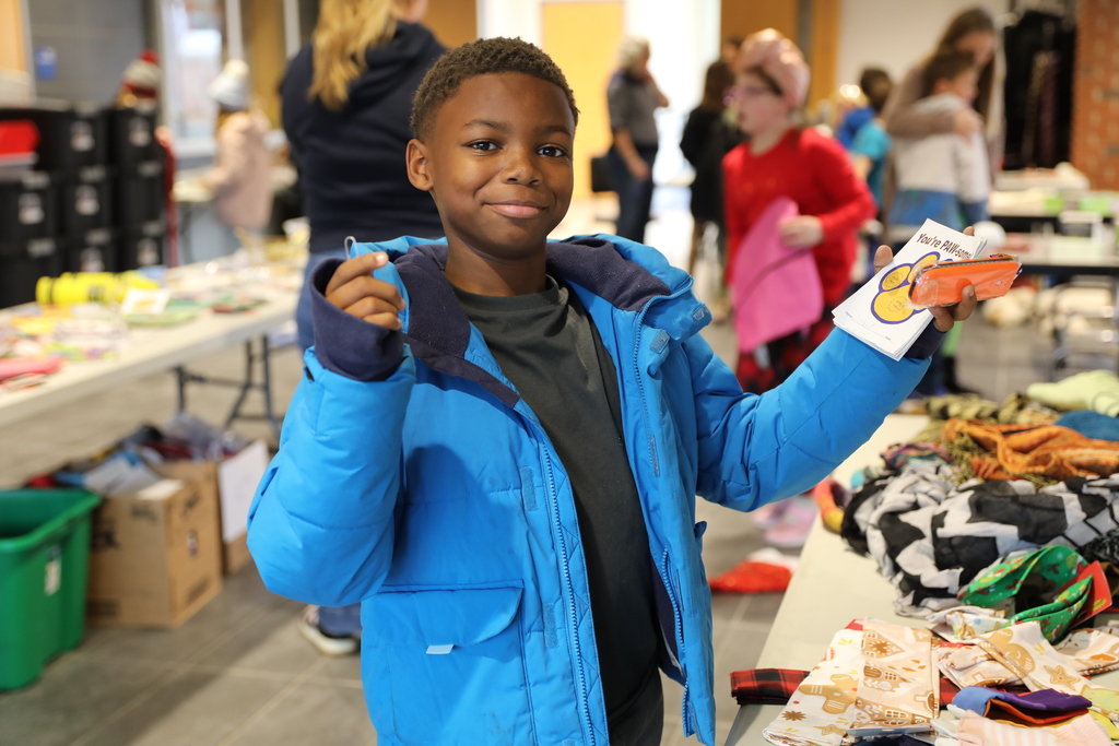 a student holding up the gifts he is getting