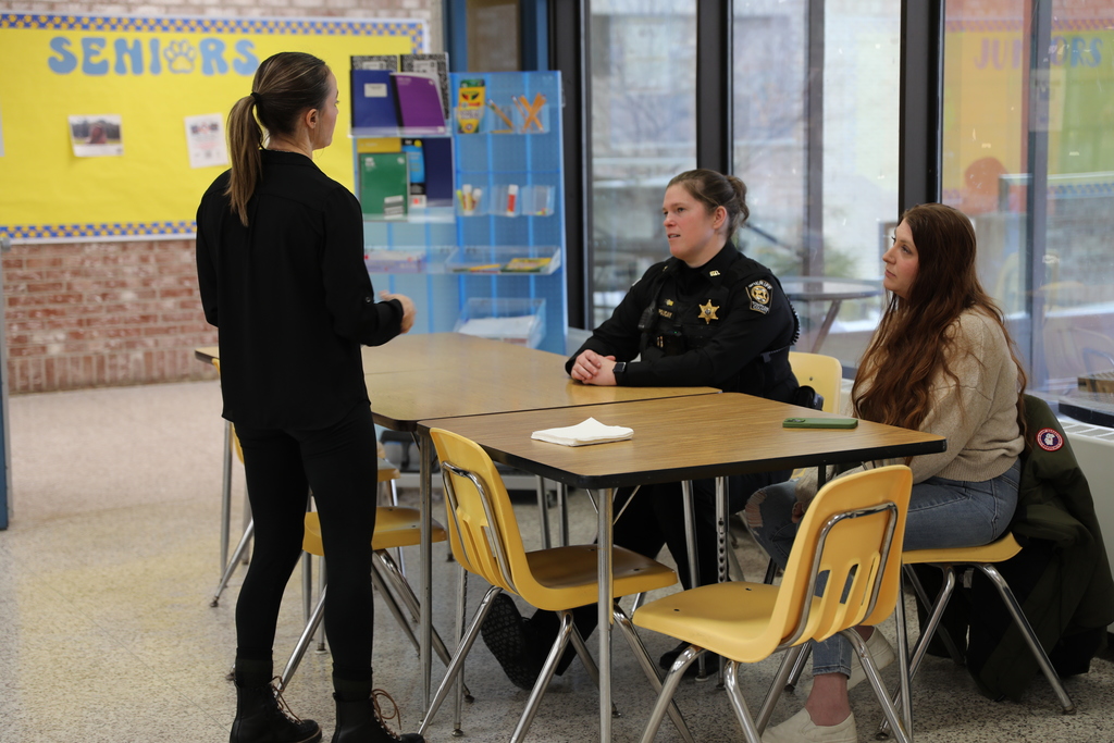 A Sheriff's deputy speaking with a staff member