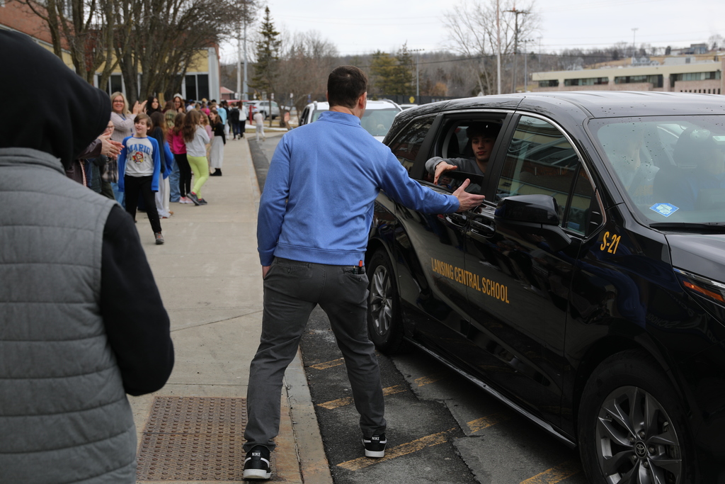 The wrestling students giving a handshake to a MS staff member as they drive by
