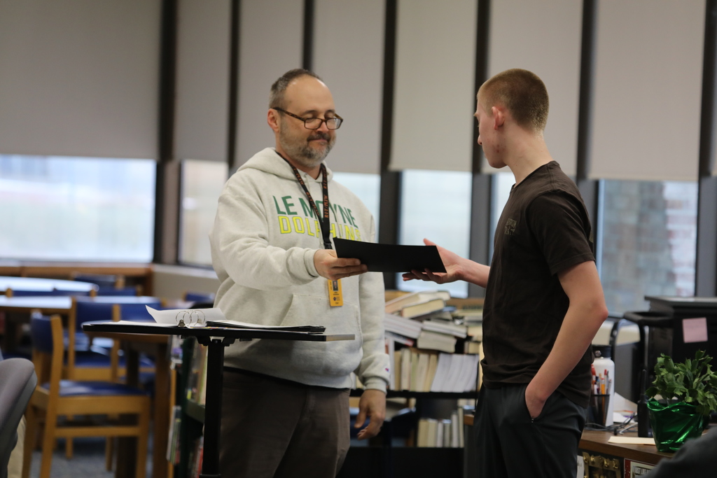 a teacher handing a student an award
