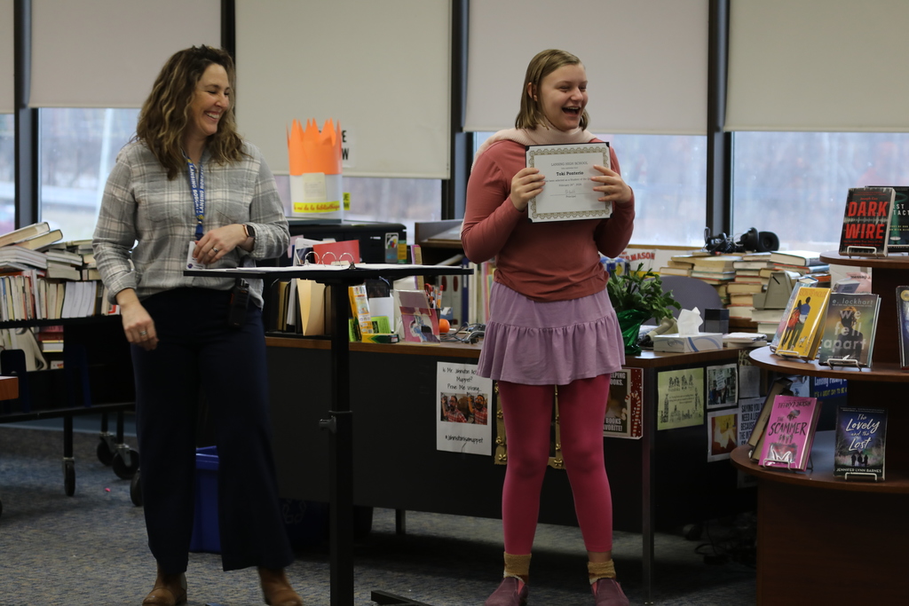 a teacher handing a student an award