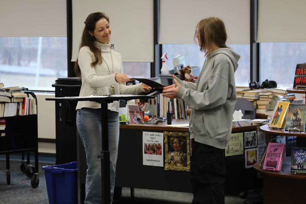 a teacher handing a student an award