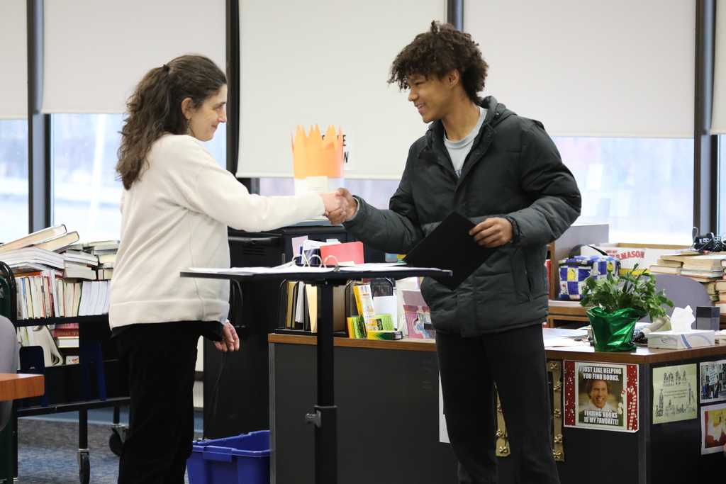 a teacher handing a student an award