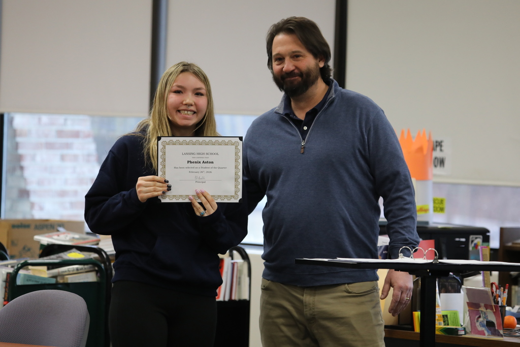 a student posing with the principle for an award