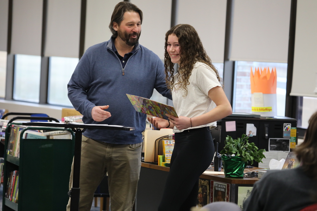 a teacher handing a student an award