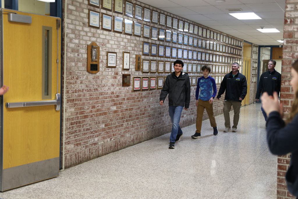 student and staff walking down the hall