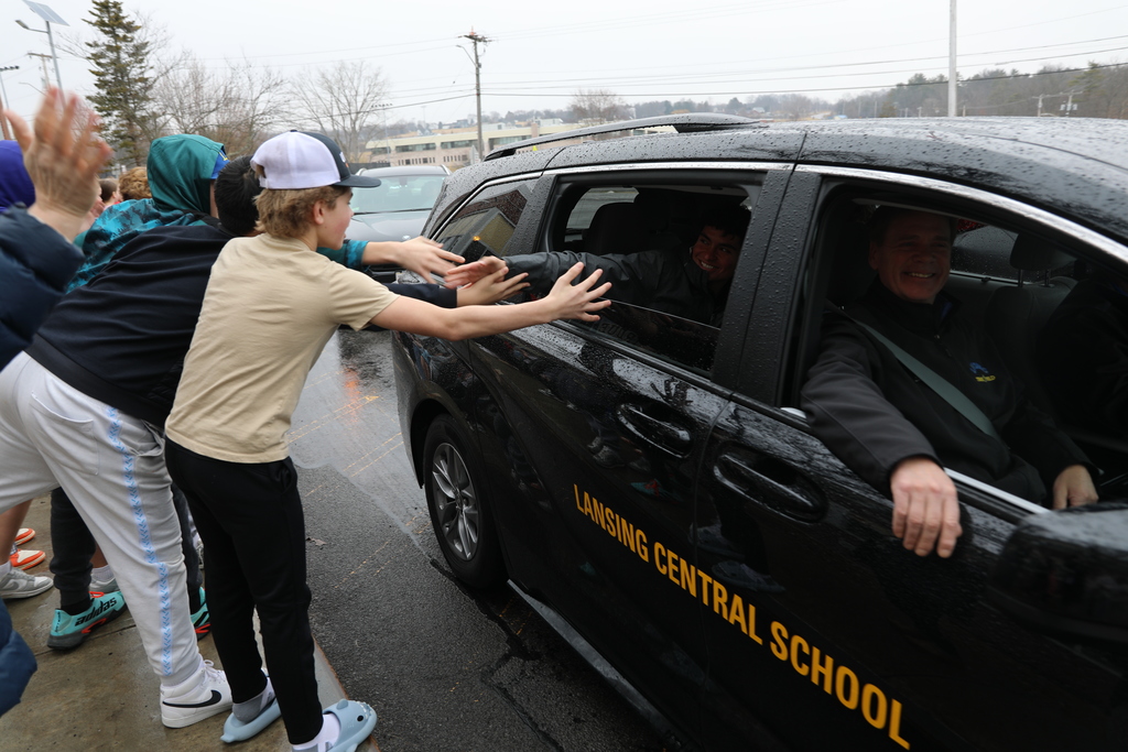 a bunch of kids touch the hands of the student going to states