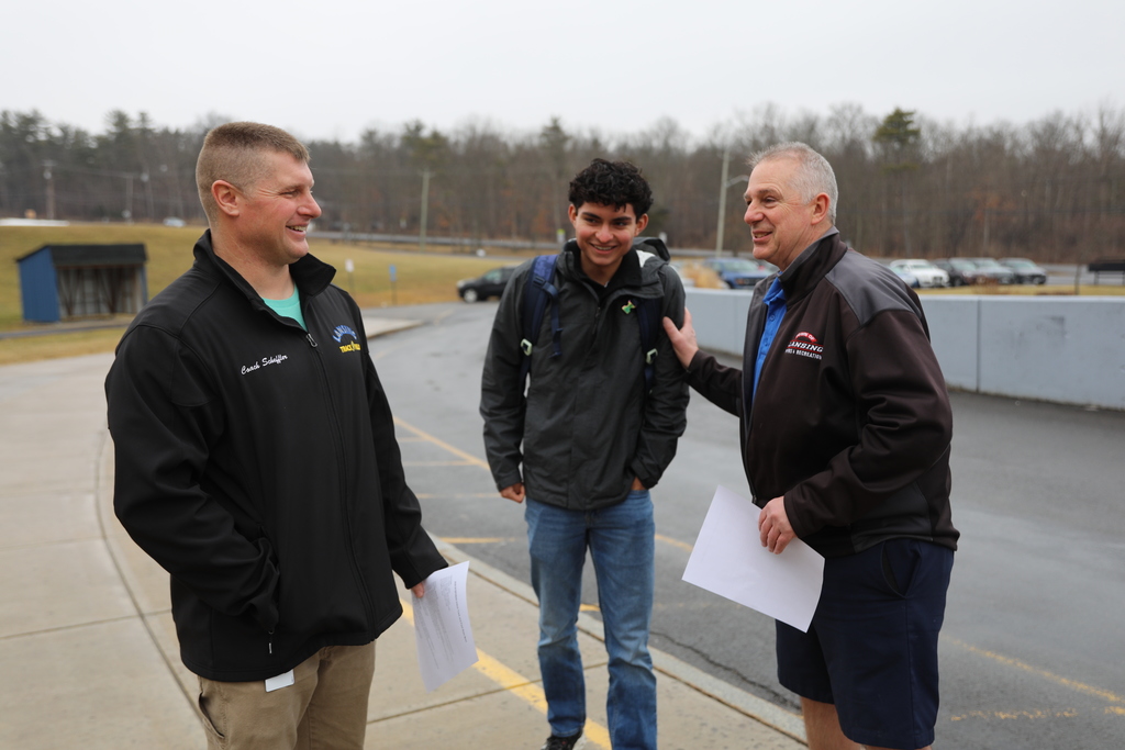 student and staff in a candid photo getting ready by car