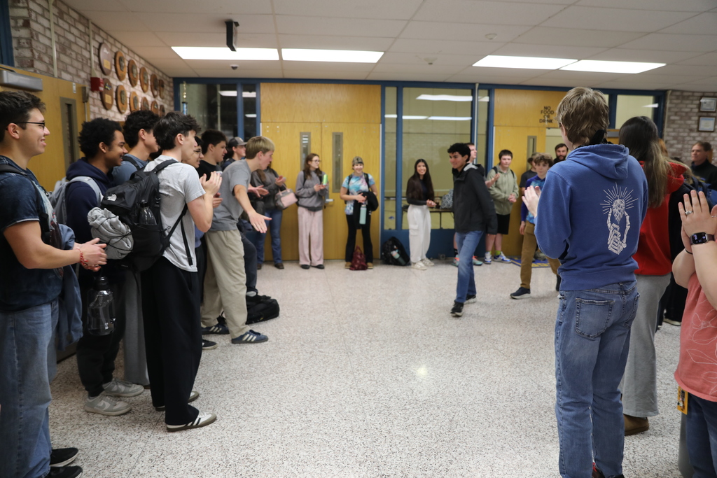 student getting cheers from other students lining the halls