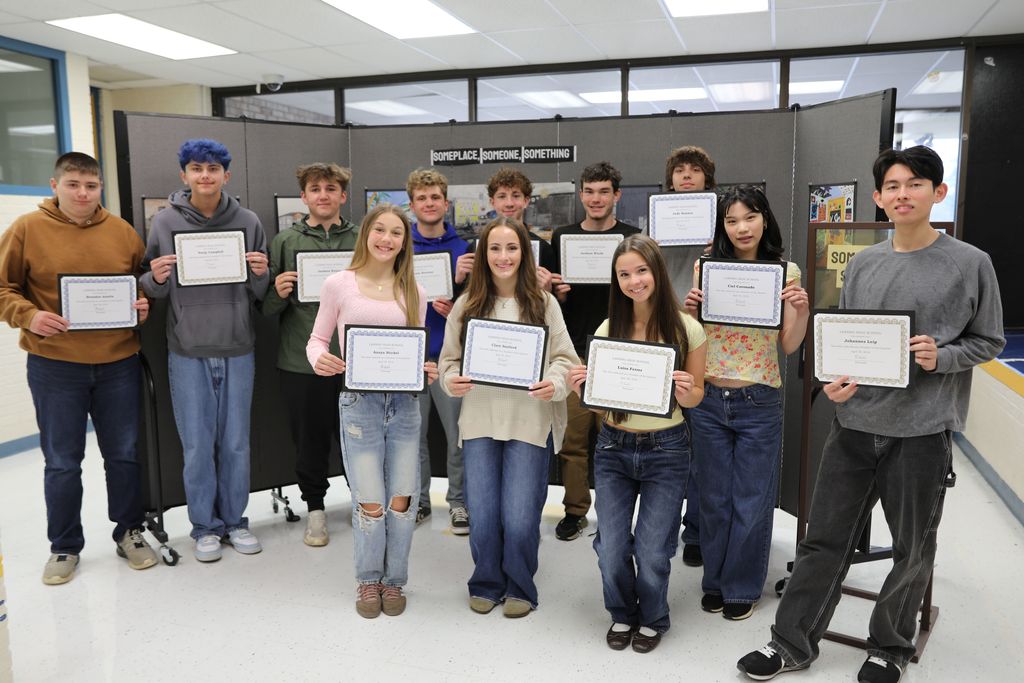 A group of students holding up their awards