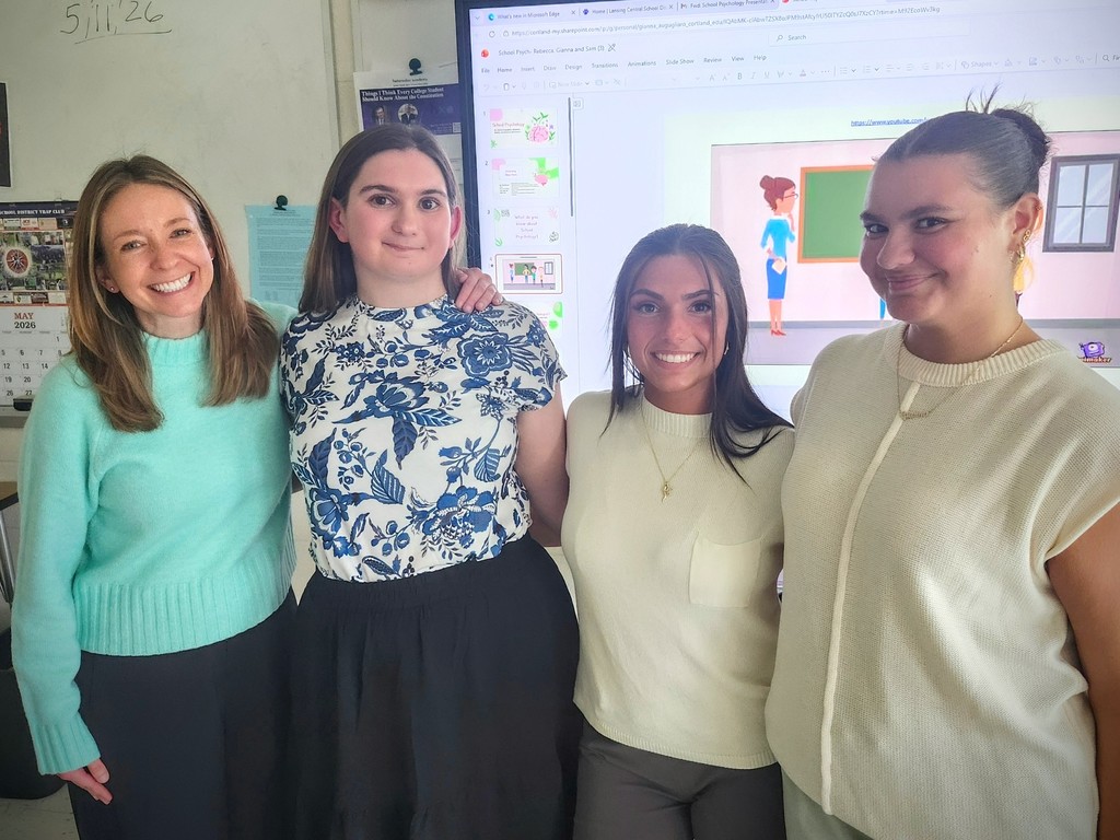 A high school counselor poses for a group photo with three SUNY Cortland psychology students following their classroom presentation about school psychology and counseling careers.