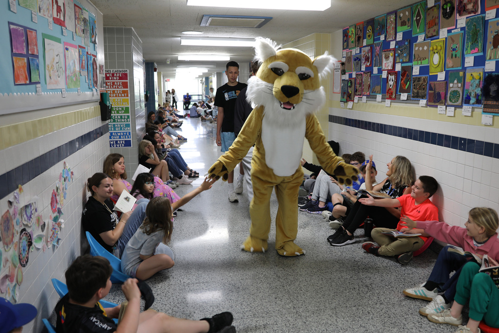 The bobcat walking down a hall full of students giving high fives