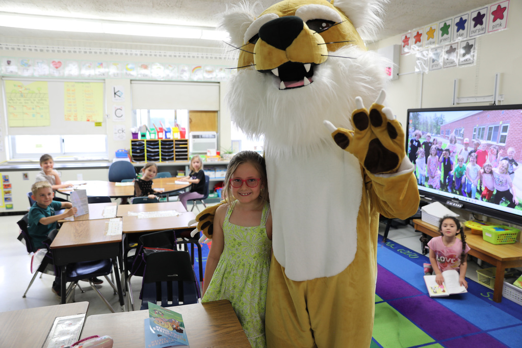 A student posing with the Bobcat for a picture