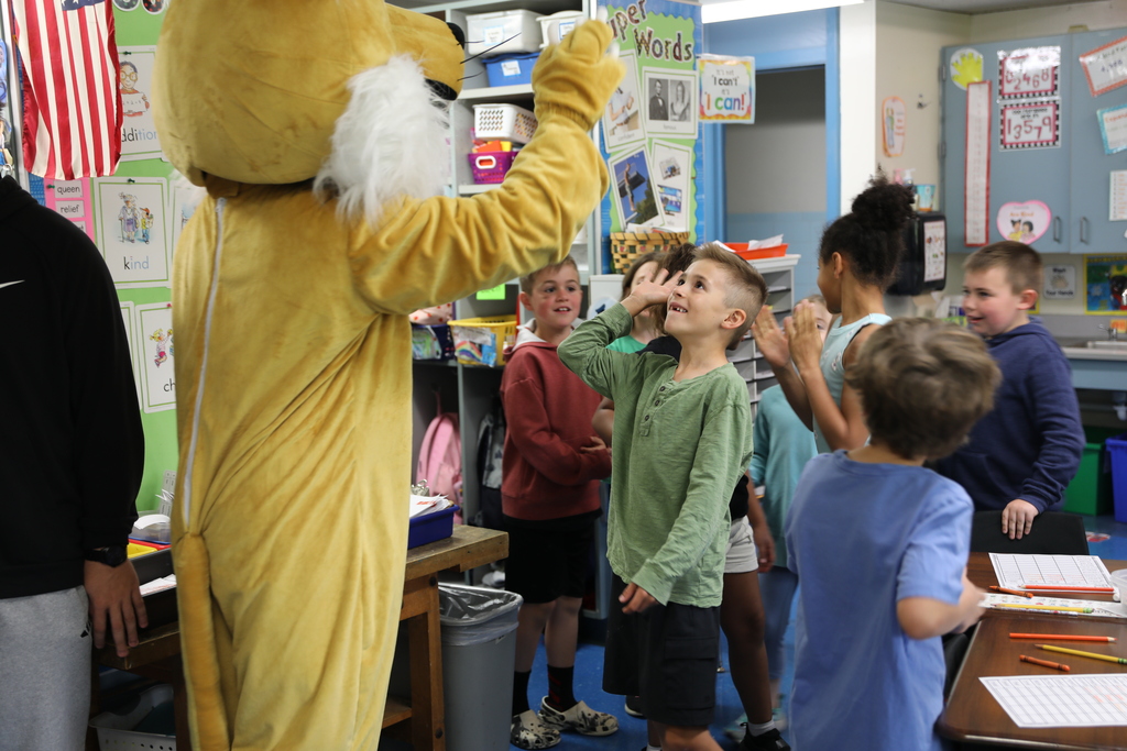 a group of students trying to give a high five to the Bobcat