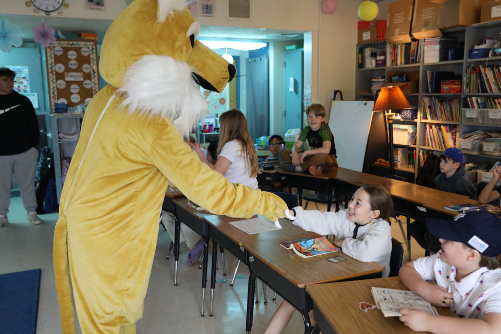 a student in a class giving a handshake to the Bobcat