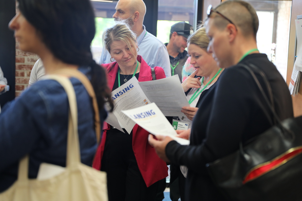a group of people looking at an itinerary of their visit to Lansing