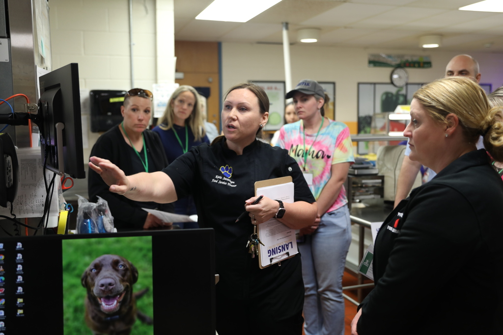 Lansing staff pointing out food scheduling on a computer screen