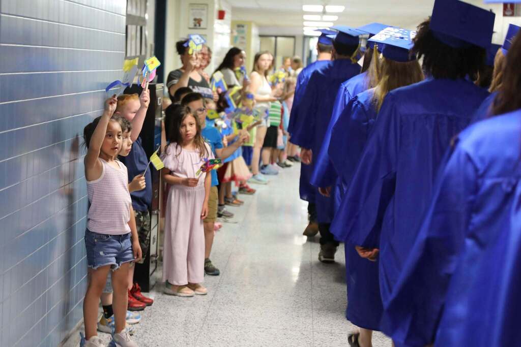 Seniors walking the halls as people cheer them on