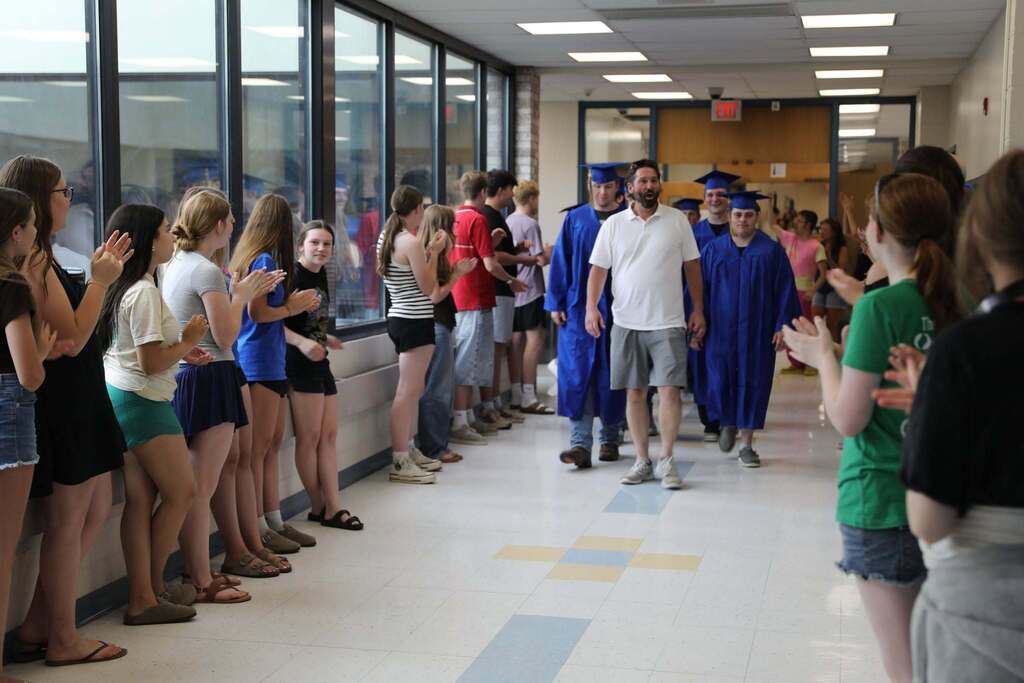 Seniors walking the halls as people cheer them on