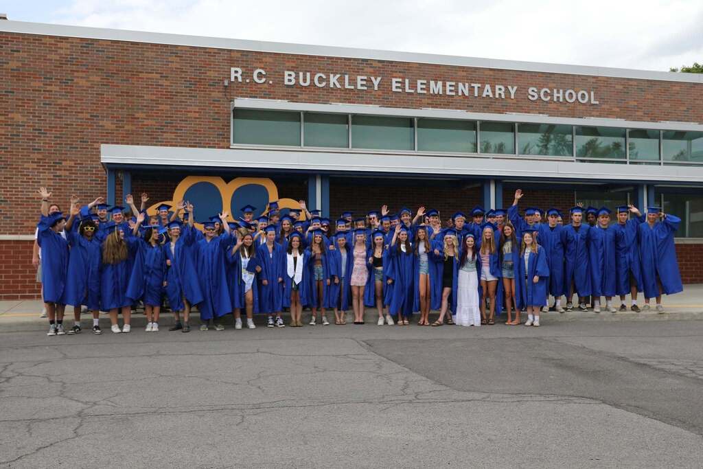 the senior class posing for a picture all together outside the elementary school