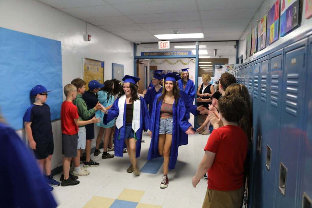 Seniors walking the halls as people cheer them on