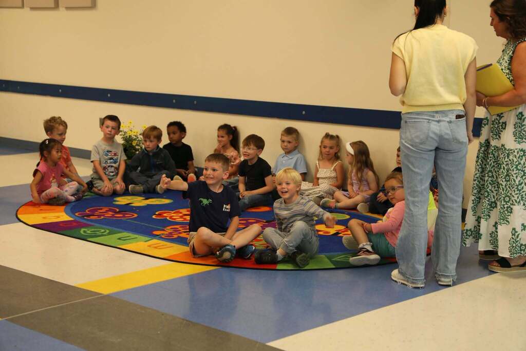 a group of PreK students sitting on a rug