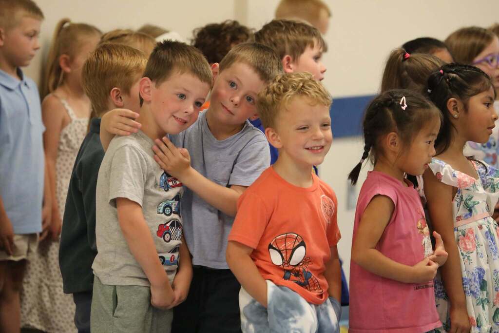 a group of students with a few smiling and two hugging